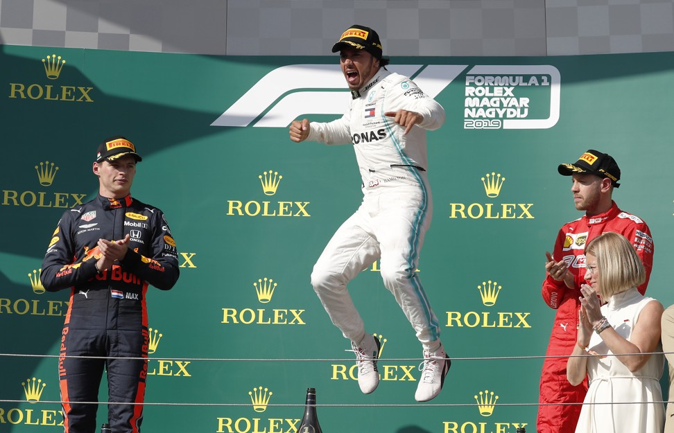 Hamilton jumps for joy as Verstappen (left) and third placed Ferrari driver Sebastian Vettel look on. Photo: AP