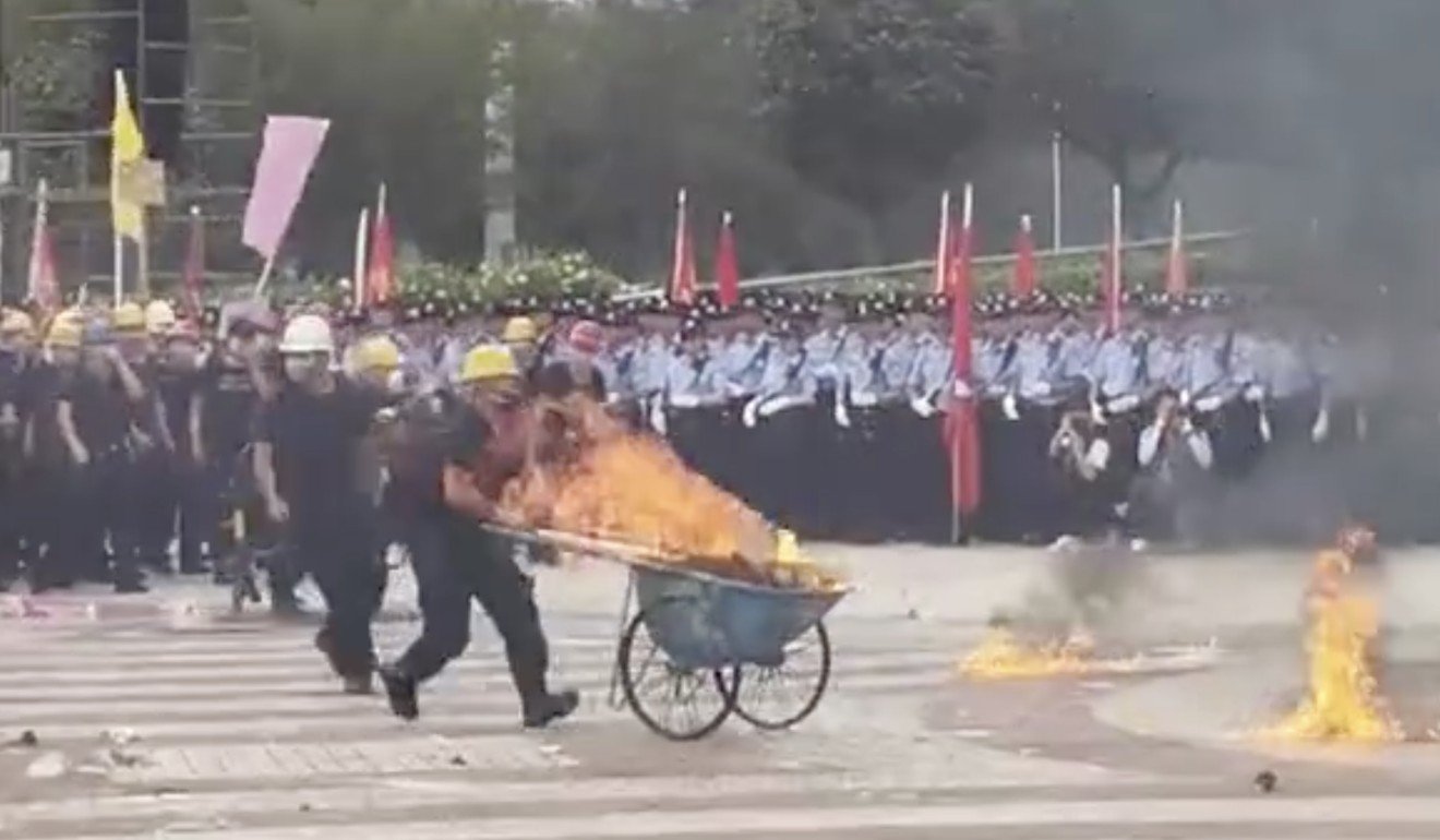 A blazing bogie is driven towards police lines during Shenzhen police’s anti-riot exercise. Photo: Weibo