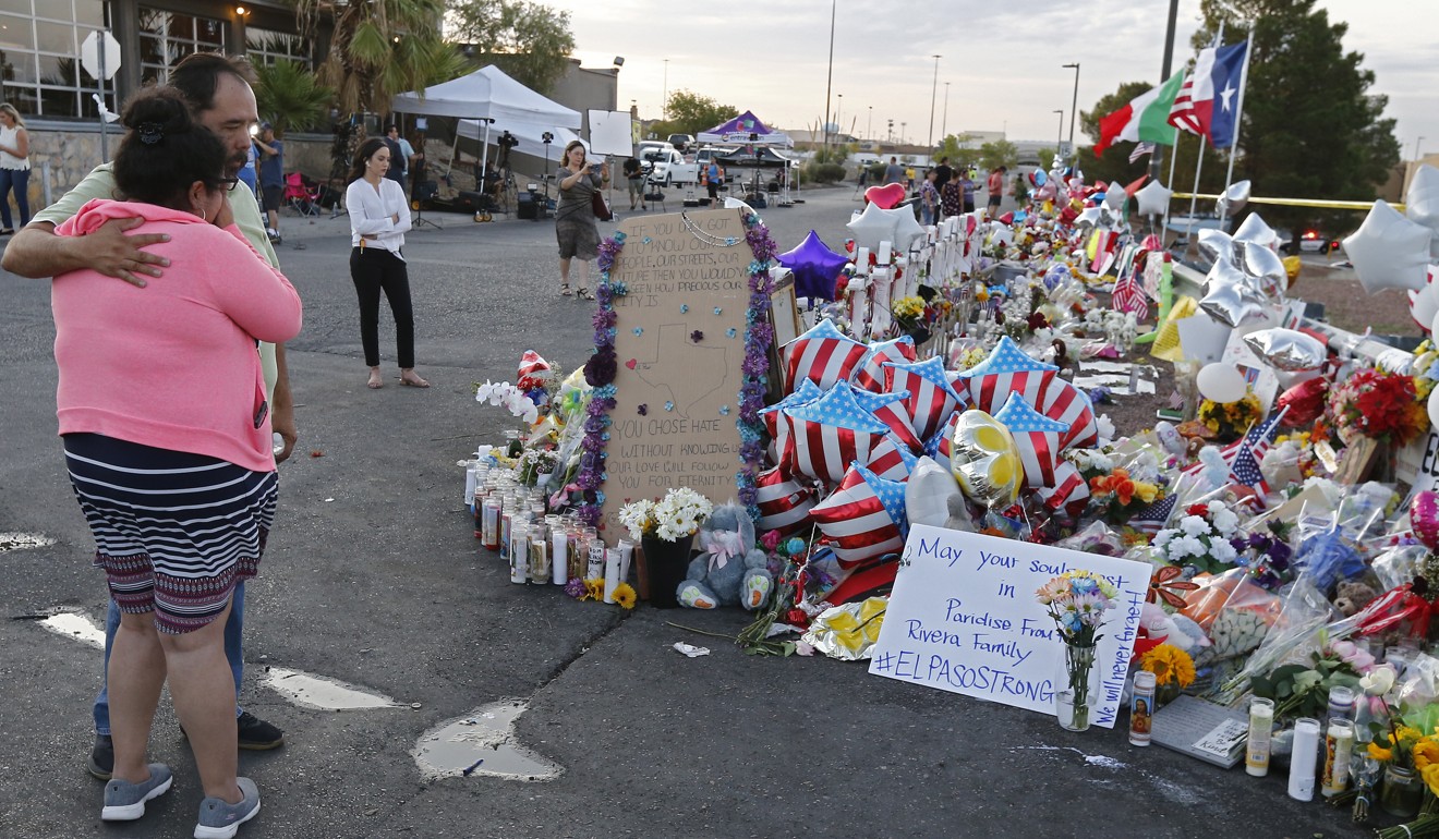 A woman and man hug at a makeshift memorial after the massacre at a Walmart store in El Paso, Texas. Photo: EPA-EFE