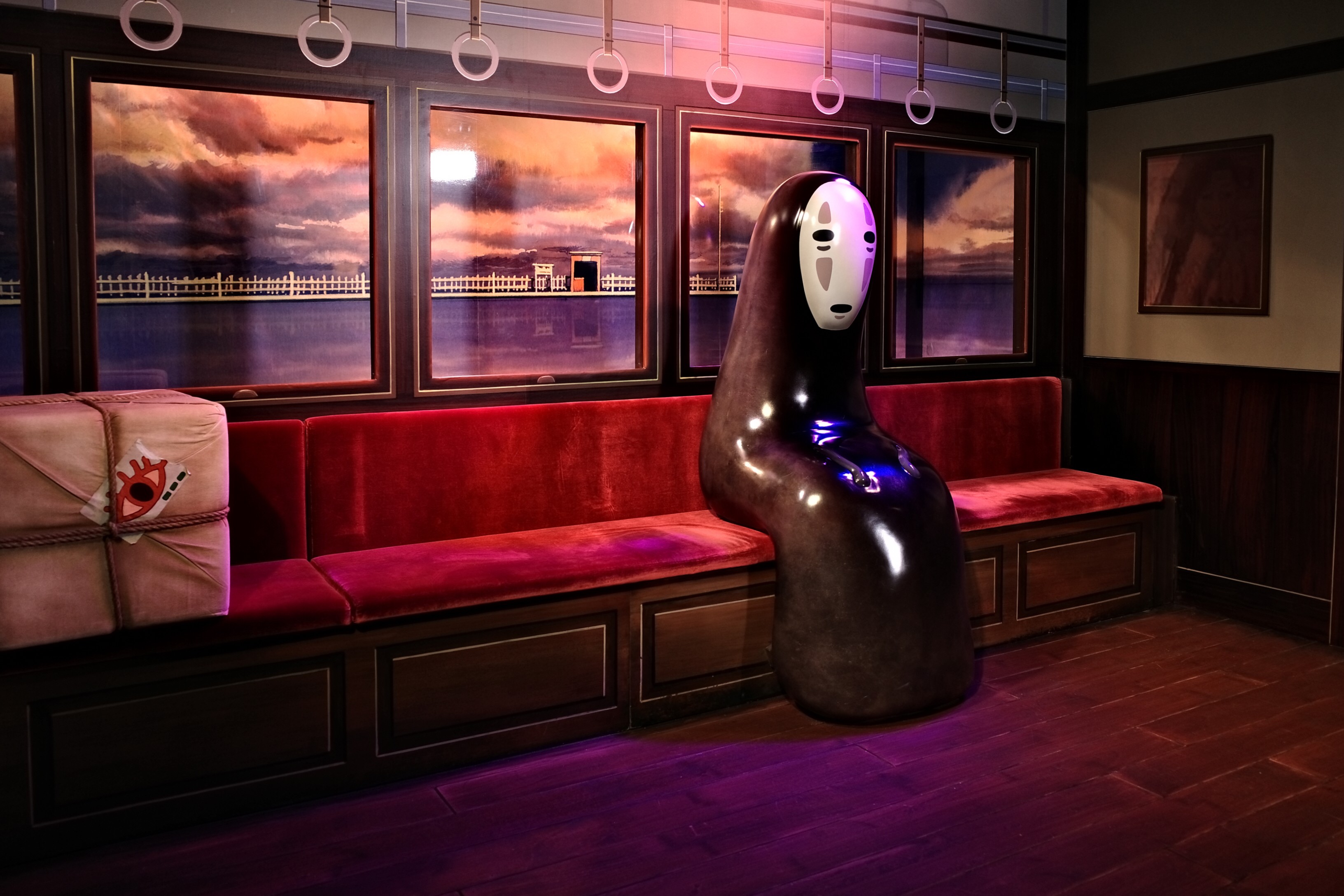 An installation of a scene from Spirited Away featuring the spirit No-man sitting on a train at sea. Photo: Oasis Li