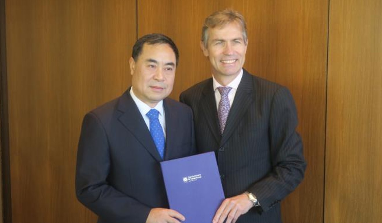 Xu Jie, the Chinese consul-general in Brisbane, being presented with a letter of appointment by Peter Hoj, president at the University of Queensland. Photo: Chinese Consulate-General in Brisbane