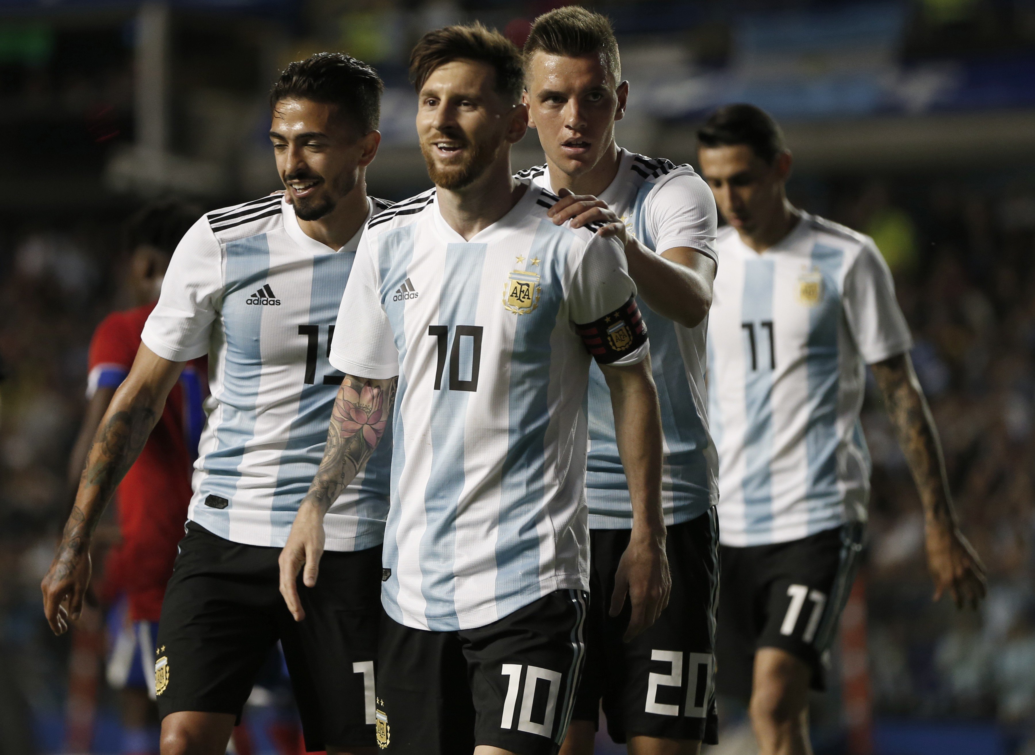 New Tottenham Hotspur signing Giovanni Lo Celso holds on to Argentina teammate Lionel Messi. Photo: AP