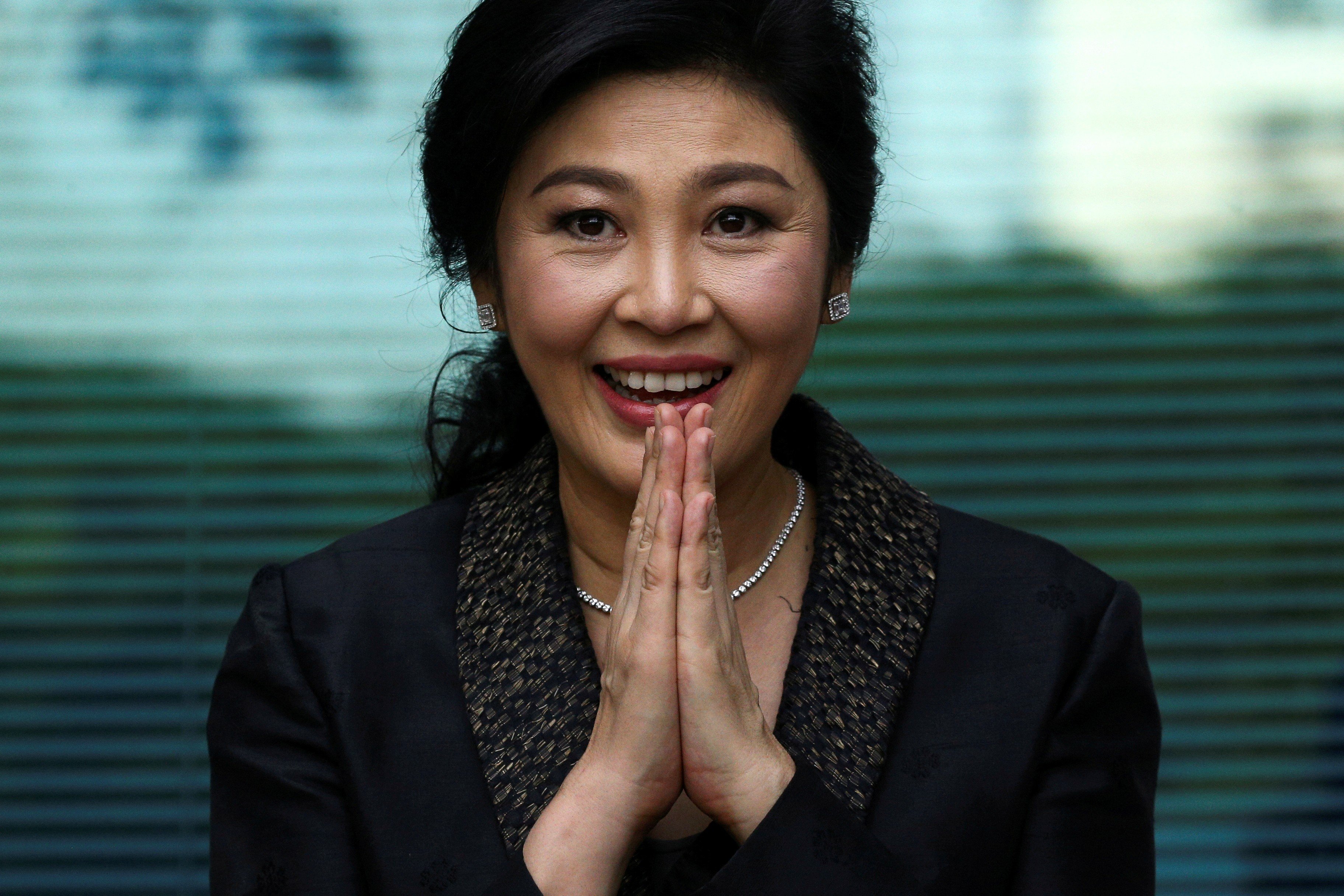 Former Thai prime minister Yingluck Shinawatra greets supporters as she arrives at the Supreme Court in Bangkok in August 2017. Photo: Reuters