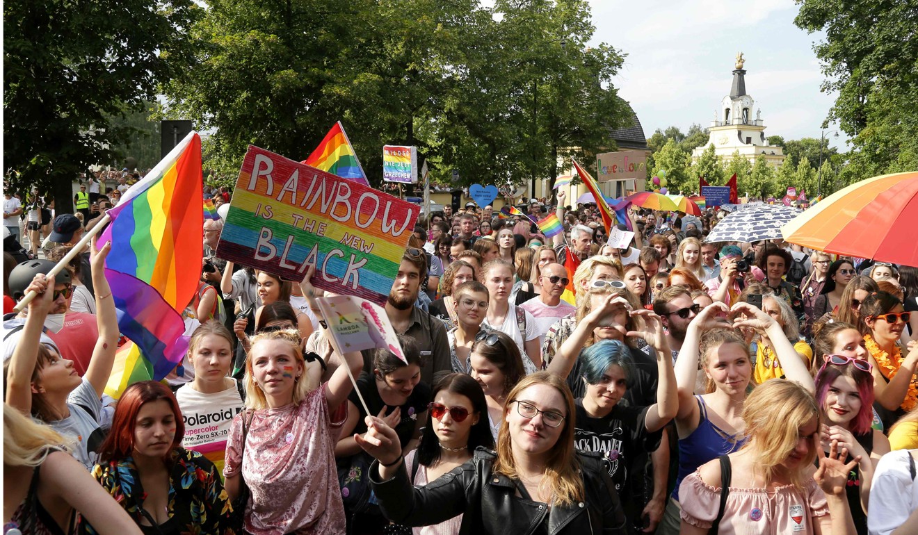 People hold flags and placards during the first gay pride march in the city of Bialystok before violence broke out. Photo: AFP