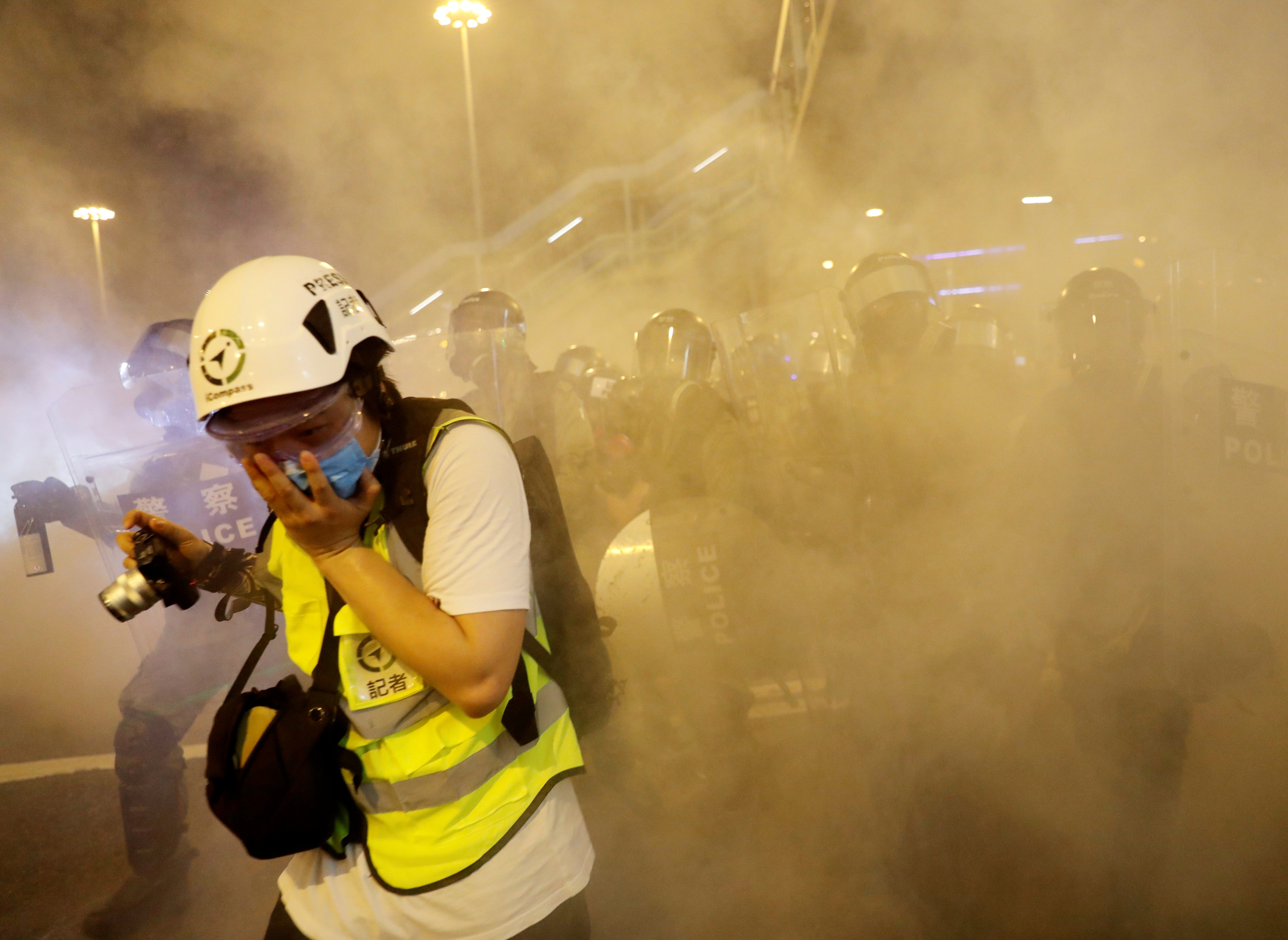 A journalist covers her face after police officers fired tear gas toward extradition bill protesters during a protest in Hong Kong on Sunday. Photo: Reuters