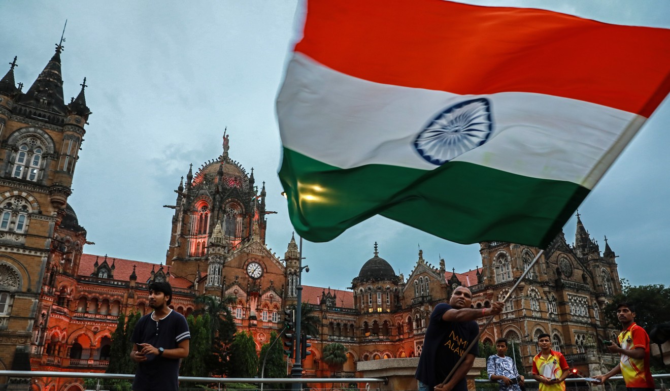 A supporter of Indian Prime Minister Narendra Modi shouts slogans and holds the Indian national flag to celebrate the removal of Article 370, in Mumbai. Photo: EPA-EFE