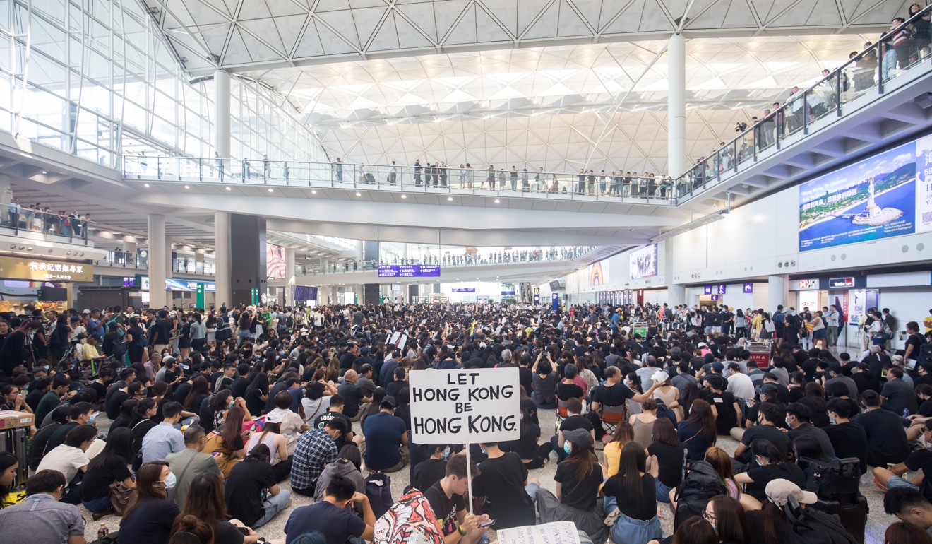 A demonstrator holds a sign reading “Let Hong Kong be Hong Kong” during a protest at the Hong Kong International Airport. Photo: Bloomberg