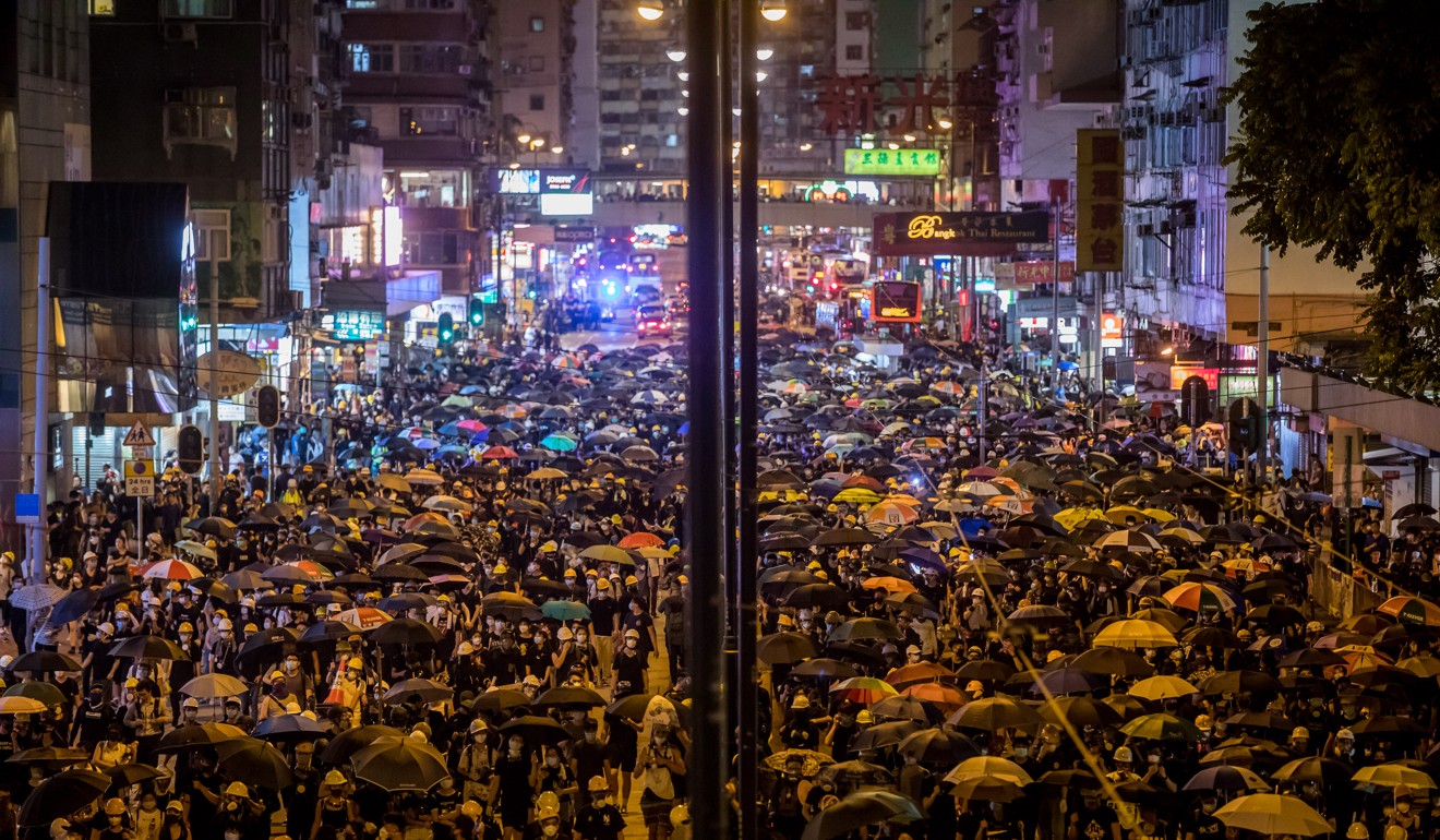 Demonstrators walk on the street during a protest in the North Point district of Hong Kong. Photo: Bloomberg