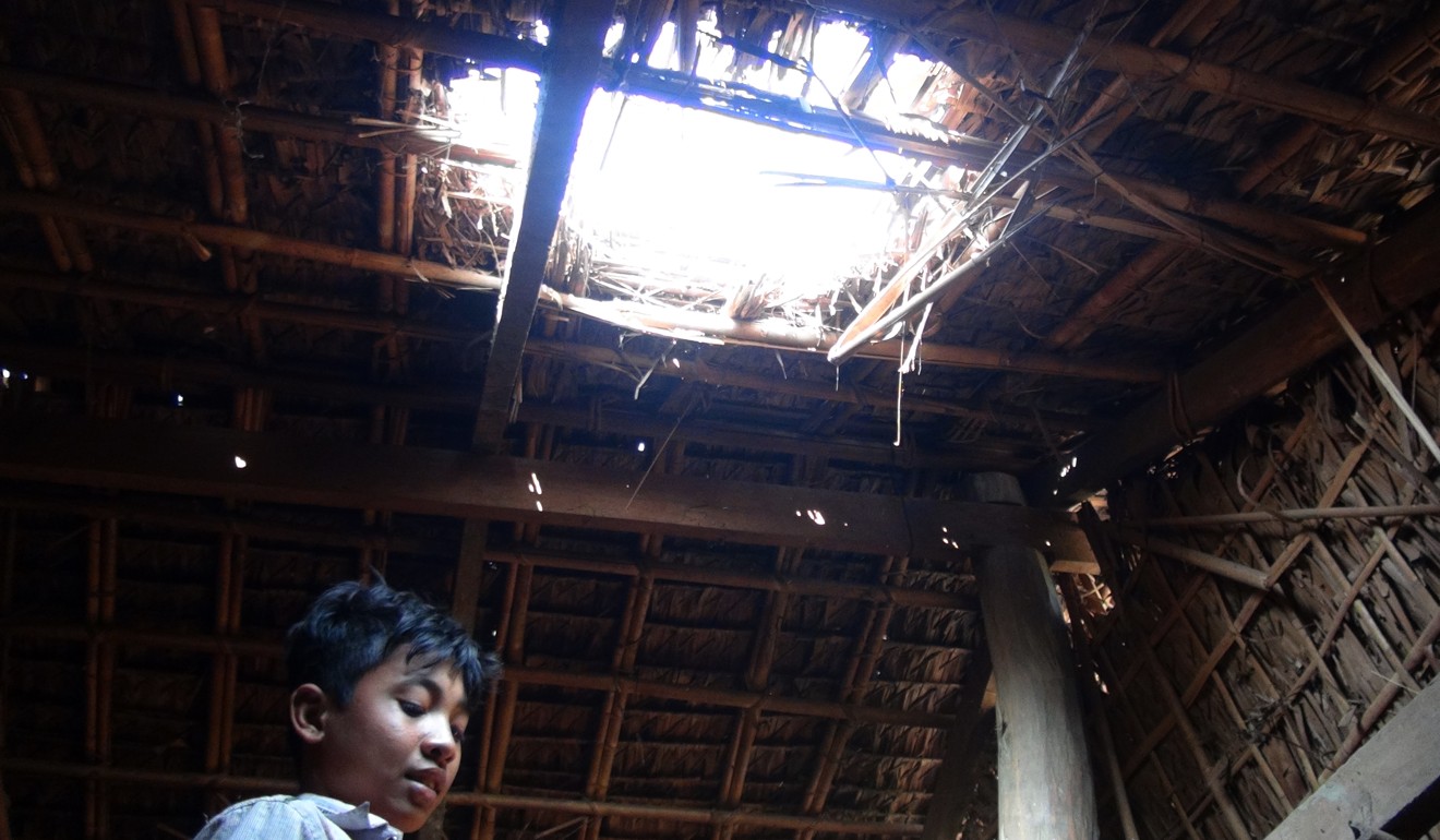 A man stands inside his house damaged by explosions and gunfire at a village in Rathedaung township, Rakhine state. Photo: AFP