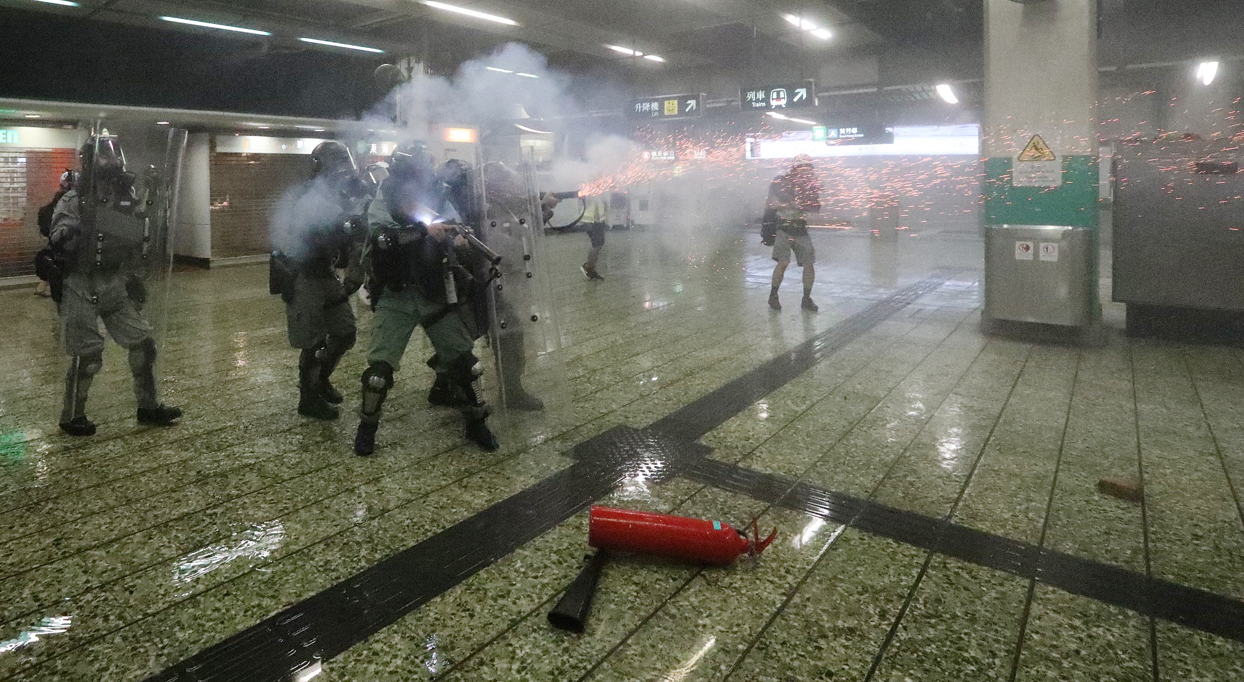 Riot police officers use tear gas inside Kwai Fong MTR station, the first time it has been used within the MTR network. Photo: Felix Wong