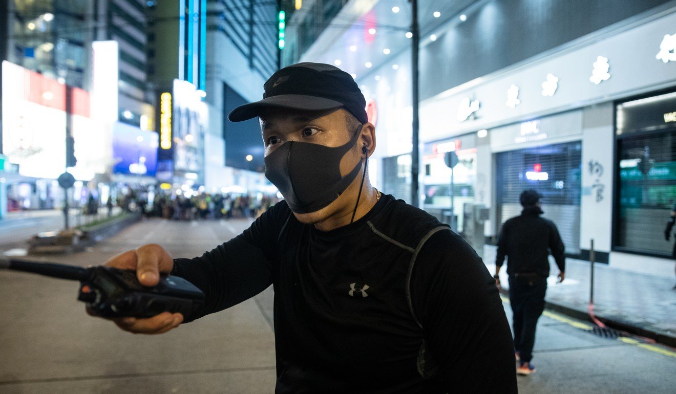 One of the men in black thought to be police. Photo: Kyle Lam/Bloomberg