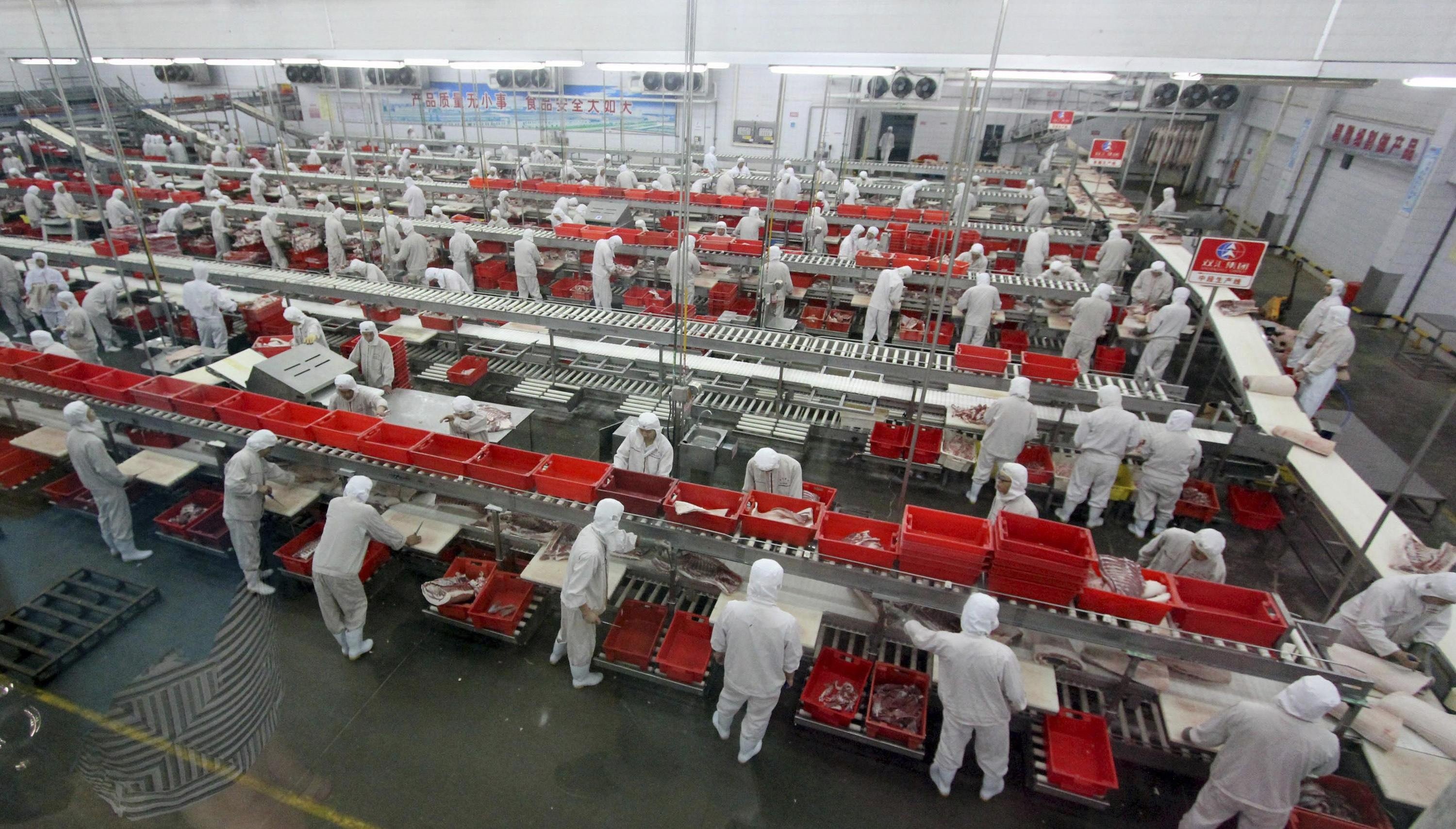 Employees process meat along a production line at a factory of Shuanghui (Shineway) Group in Luohe, Henan province, on June 17, 2013. Photo: Reuters
