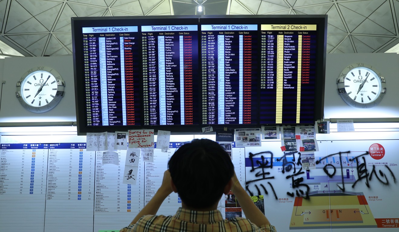 A tourist takes a photo of the electronic board showing cancelled flights. Photo: Sam Tsang
