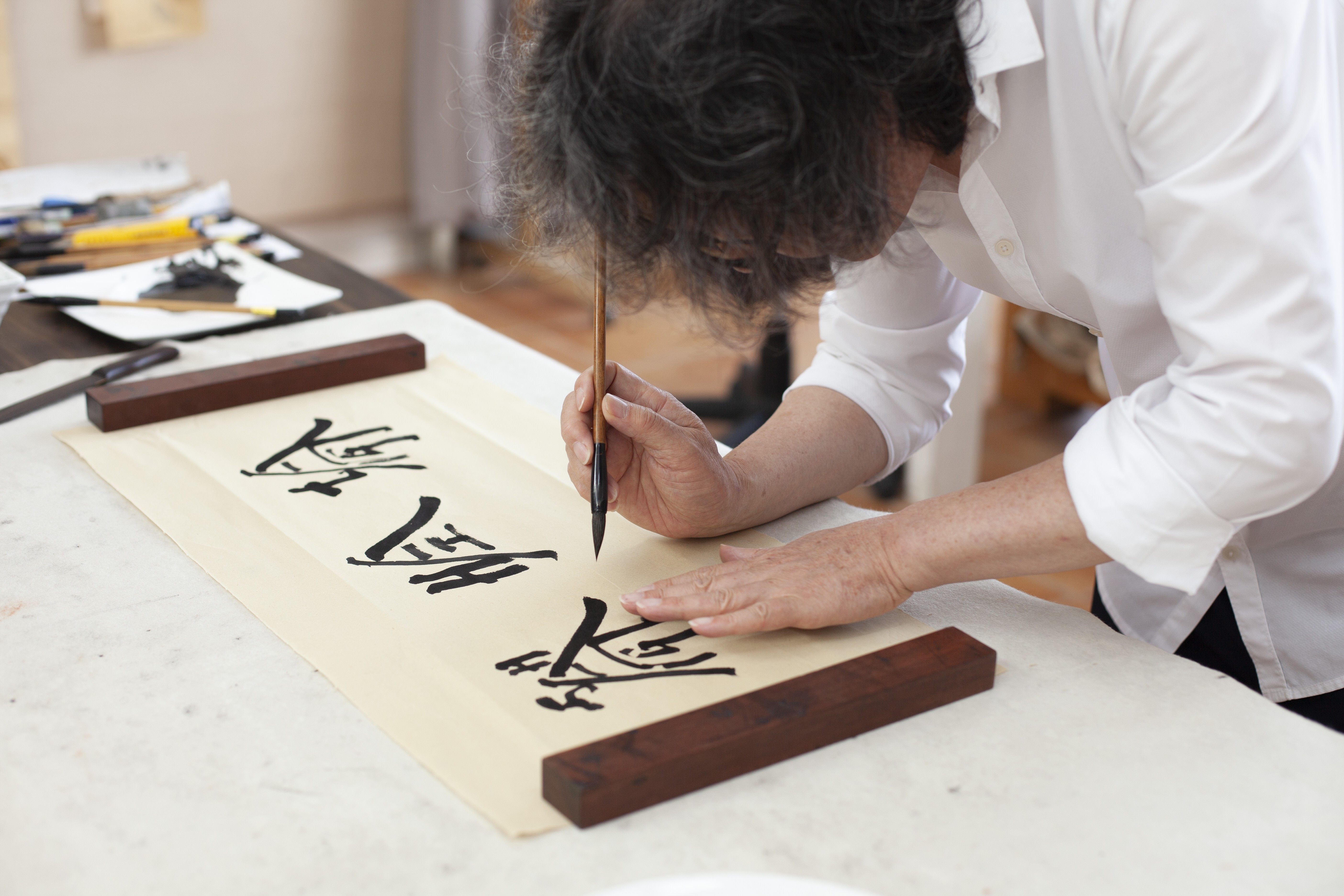 Chinese artist Xu Bing works on his distinctive art for Shanghai Tang, the luxury fashion brand which this year celebrates its 25th anniversary.