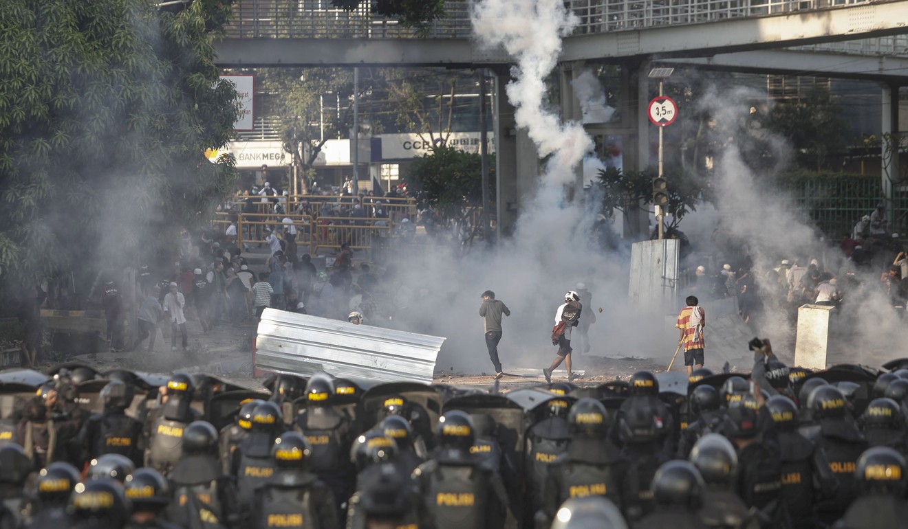 Indonesian riot police officers fire tear gas to disperse supporters of Indonesian presidential candidate Prabowo Subianto. Photo: AP