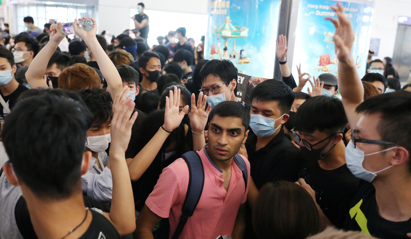Travellers attempt to navigate through a crowd of anti-government protesters at Hong Kong International Airport on Tuesday. Photo: Sam Tsang
