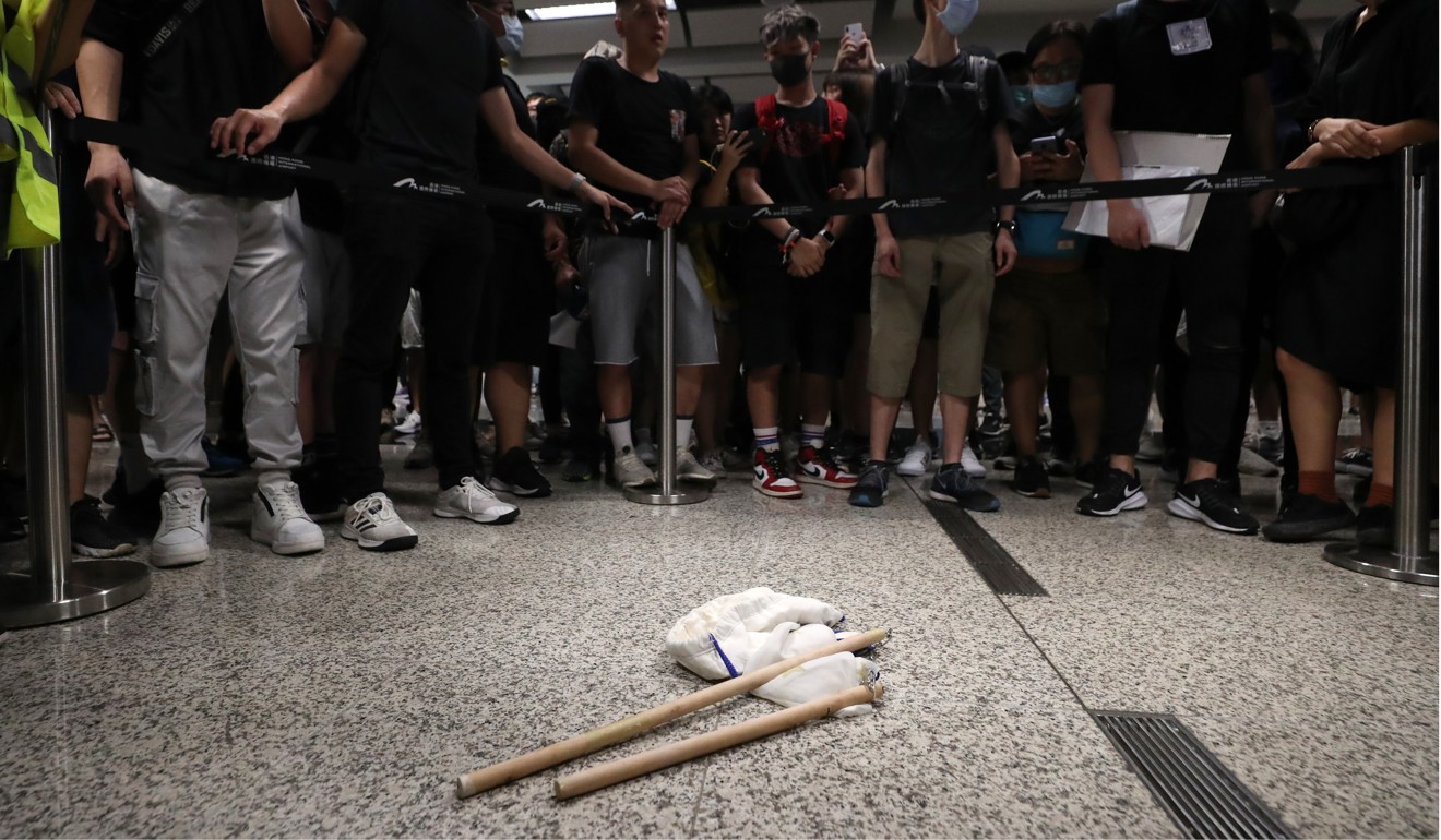 Protesters with sticks they found that were carried by a man they apprehended at Hong Kong International Airport. Photo: Sam Tsang