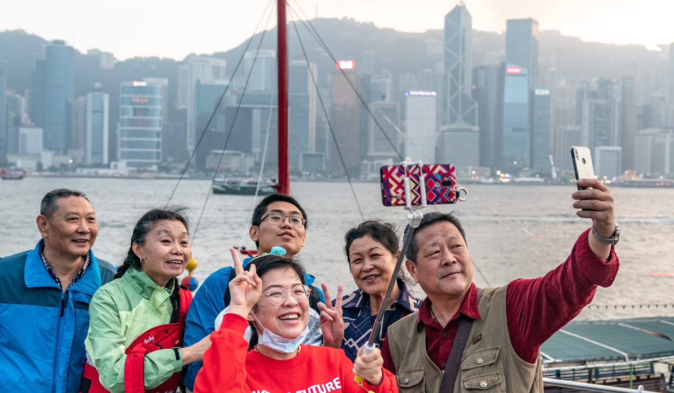 Tourists taking selfies in Victoria Harbour in Hong Kong. Photo: Bloomberg