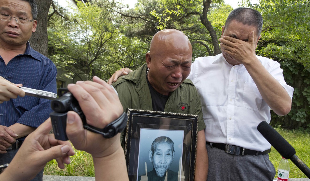 Ma Wenyi holds a photo of his father, who was forced to work during World War II at a mine for Mitsubishi Mining Corp. as he talks to journalists in Beijing in June 2016. Mitsubishi Materials Corp, one of dozens of Japanese companies that used Chinese forced labourers during World War II, reached a settlement with thousands of Chinese victims in 2016. Photo: AP