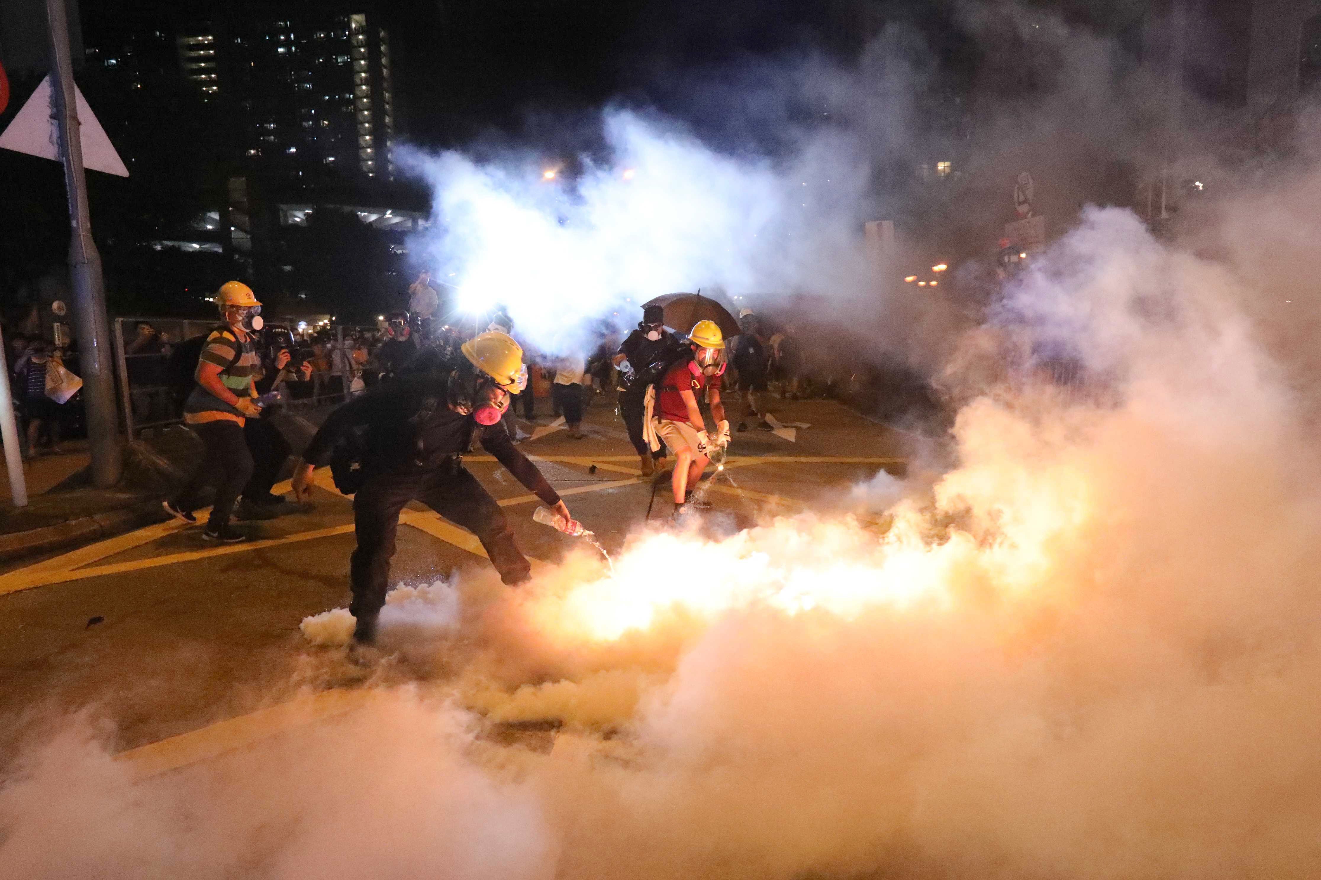 Anti-extradition bill protesters extinguish tear gas canisters during a clash with police on August 3, in Wong Tai Sin, Hong Kong. Picture: Felix Wong
