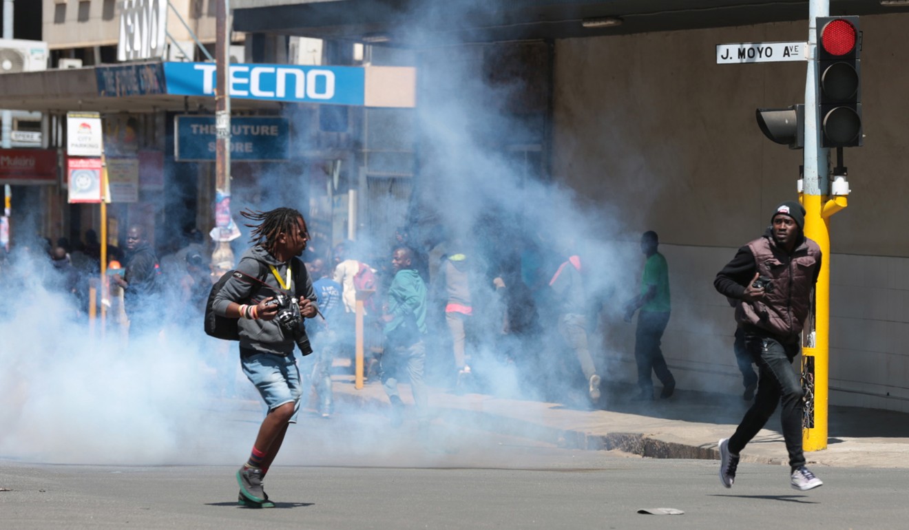 People flee as police fire tear gas to disperse protesters in Harare on Friday. Photo: EPA-EFE
