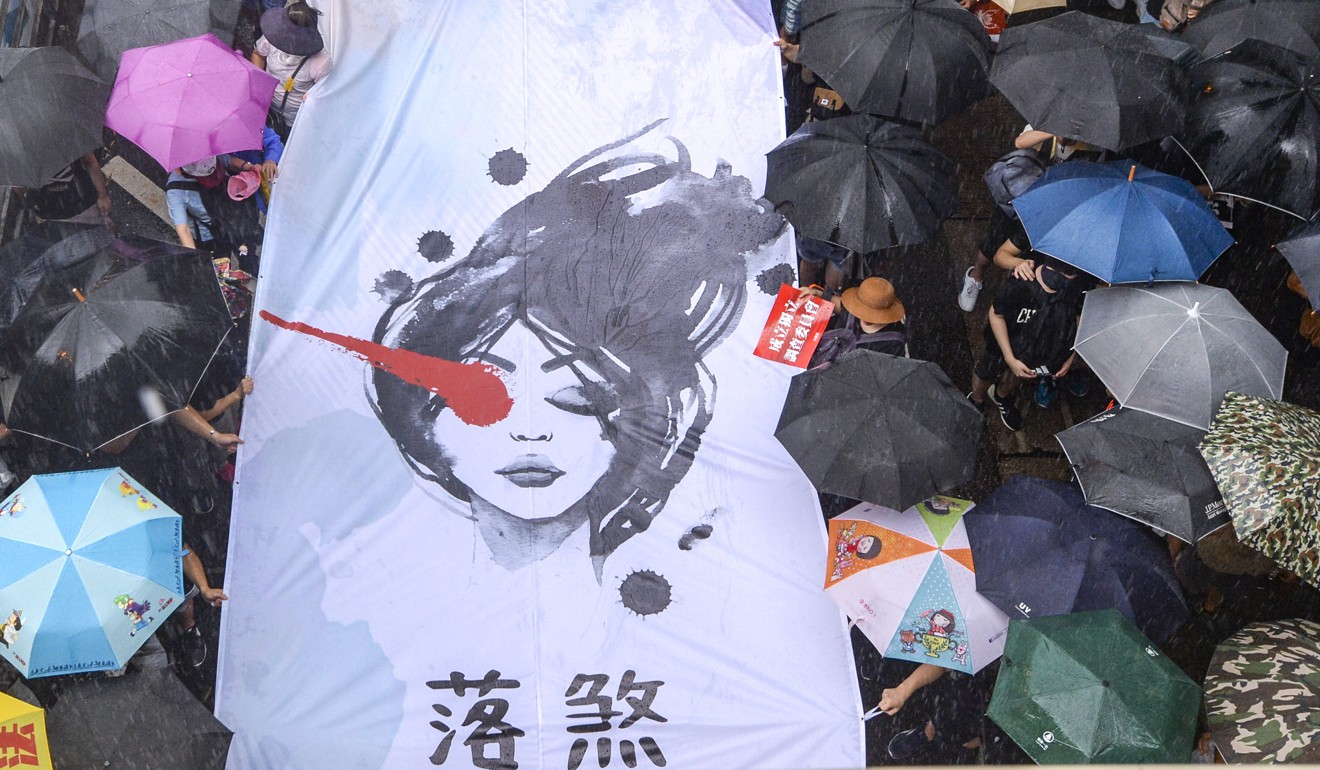 A poster of the woman hit in the eye, allegedly by a police beanbag round, at Sunday’s march. Photo: Felix Wong