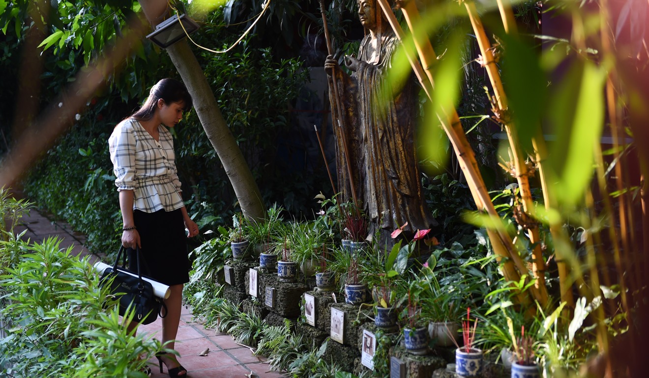A young woman looks at the graves of dogs and cats at Te Dong Vat Nga pagoda. Photo: Nhac Nguyen/AFP