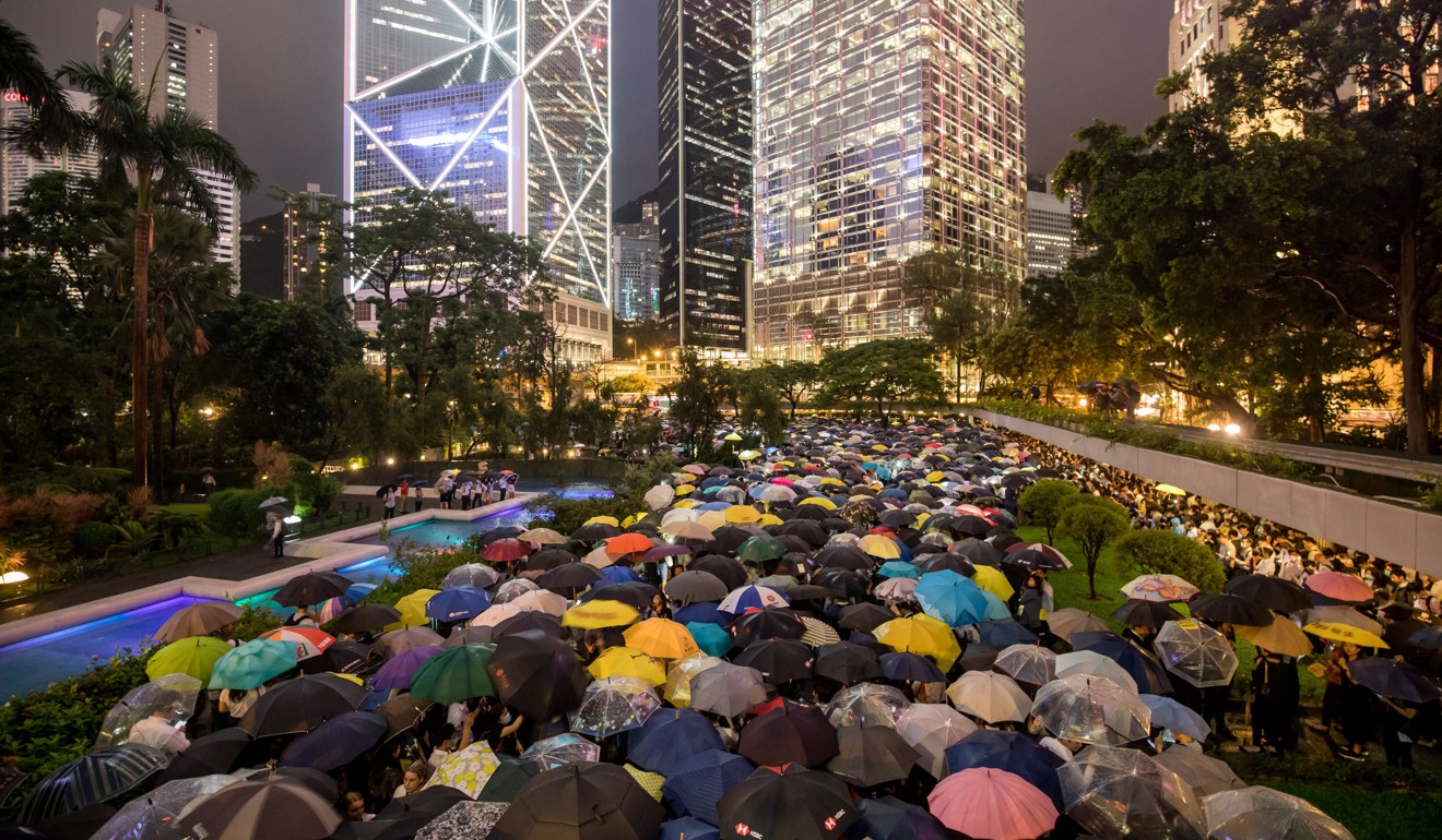 Demonstrators hold umbrellas during a financial workers’ ‘flash mob’ protest at Chater Garden in Central, Hong Kong. Photo: Bloomberg