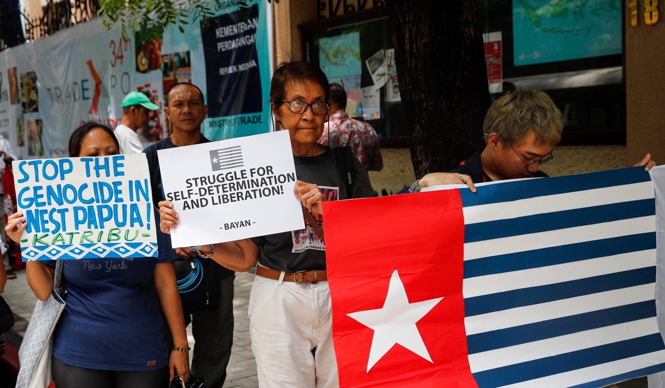 Activists hold banners and a West Papua flag (Morning Star flag). Photo: EPA-EFE