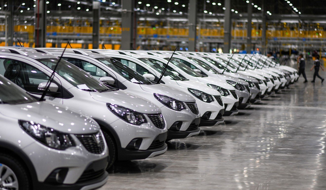 Workers walk past finished cars at the assembly plant of VinFast. Photo: AFP