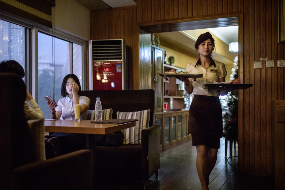 A customer uses a smart phone at Pyongyang’s SoGwang Green Leaf Coffee Shop. Photo: AFP