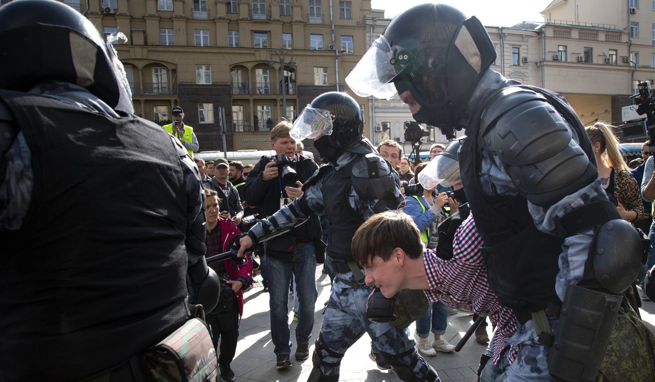 Police officers detain a protester during an unsanctioned rally in Moscow on August 3. Photo: AP