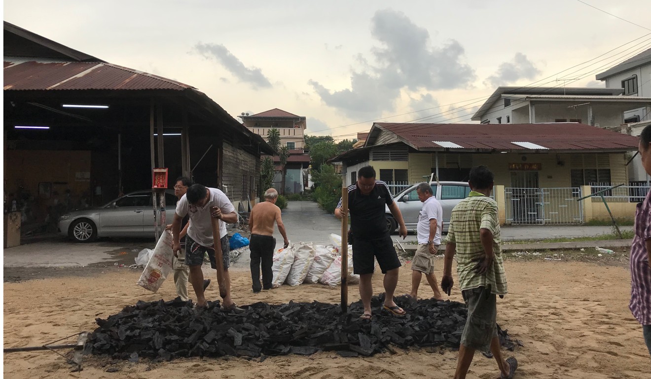 Villagers prepare charcoal for a temple ceremony in Kampung Cempaka new village. Photo: Project Community Kampung Cempaka