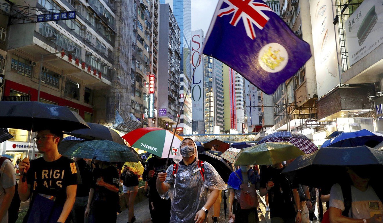 A protester waves a colonial-era flag at a protest on Sunday. Photo: Vincent Yu