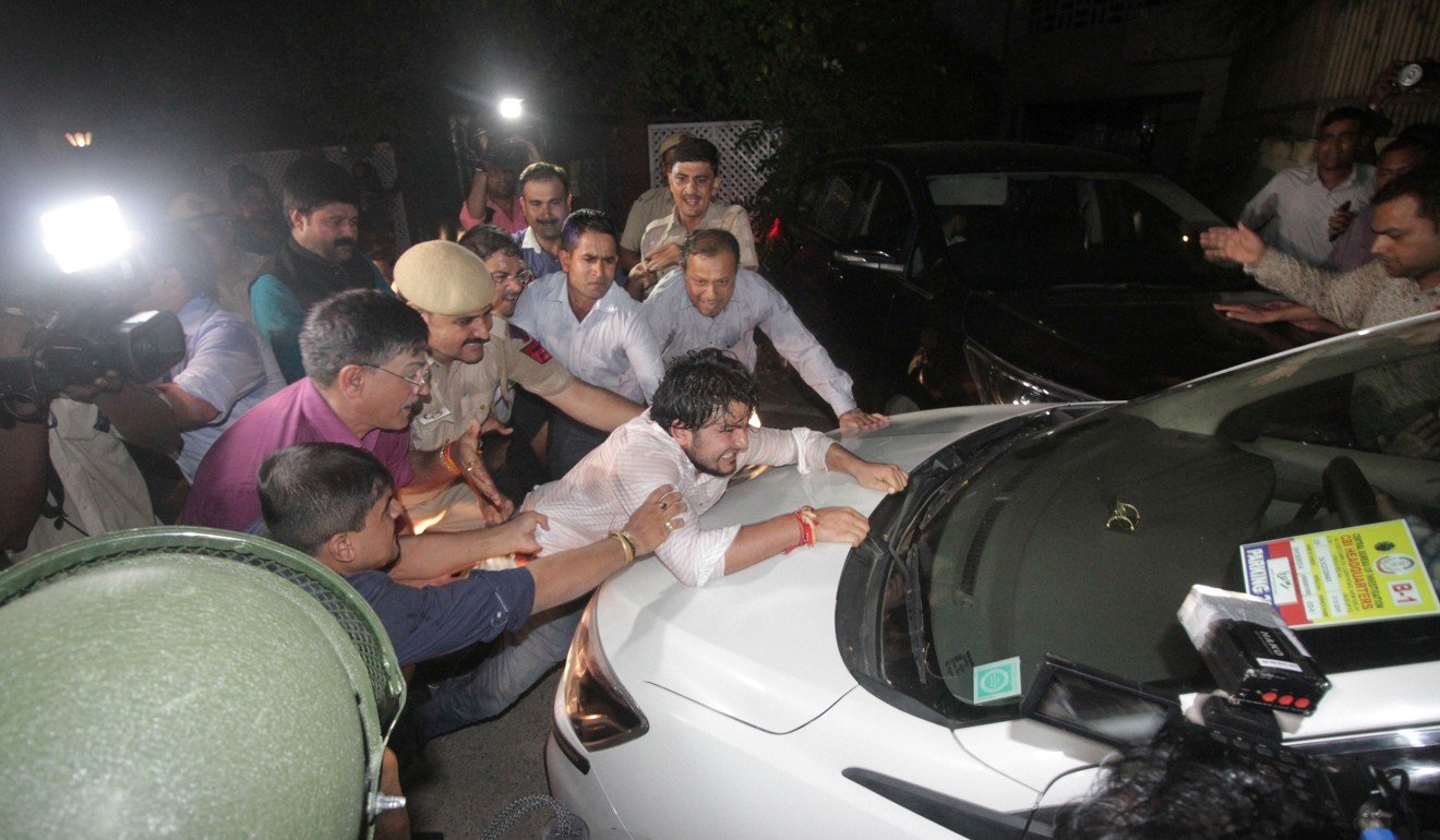 A supporter tries to stop a vehicle carrying Chidambaram after he was arrested. Photo: Reuters