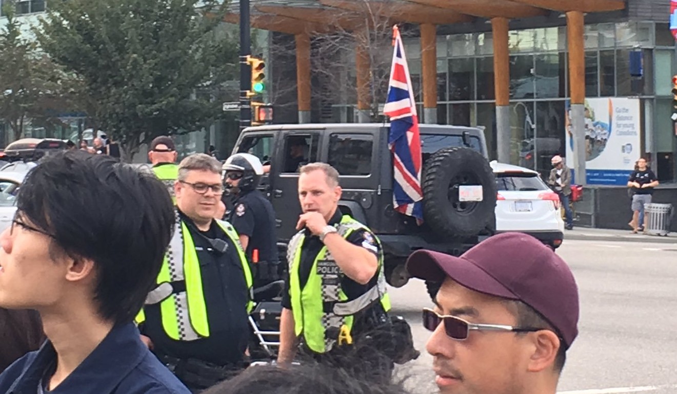 A Jeep displays a British Union flag as it passes protesters in Vancouver's Broadway on Saturday. Photo: Kevin Huang Yi Shuen