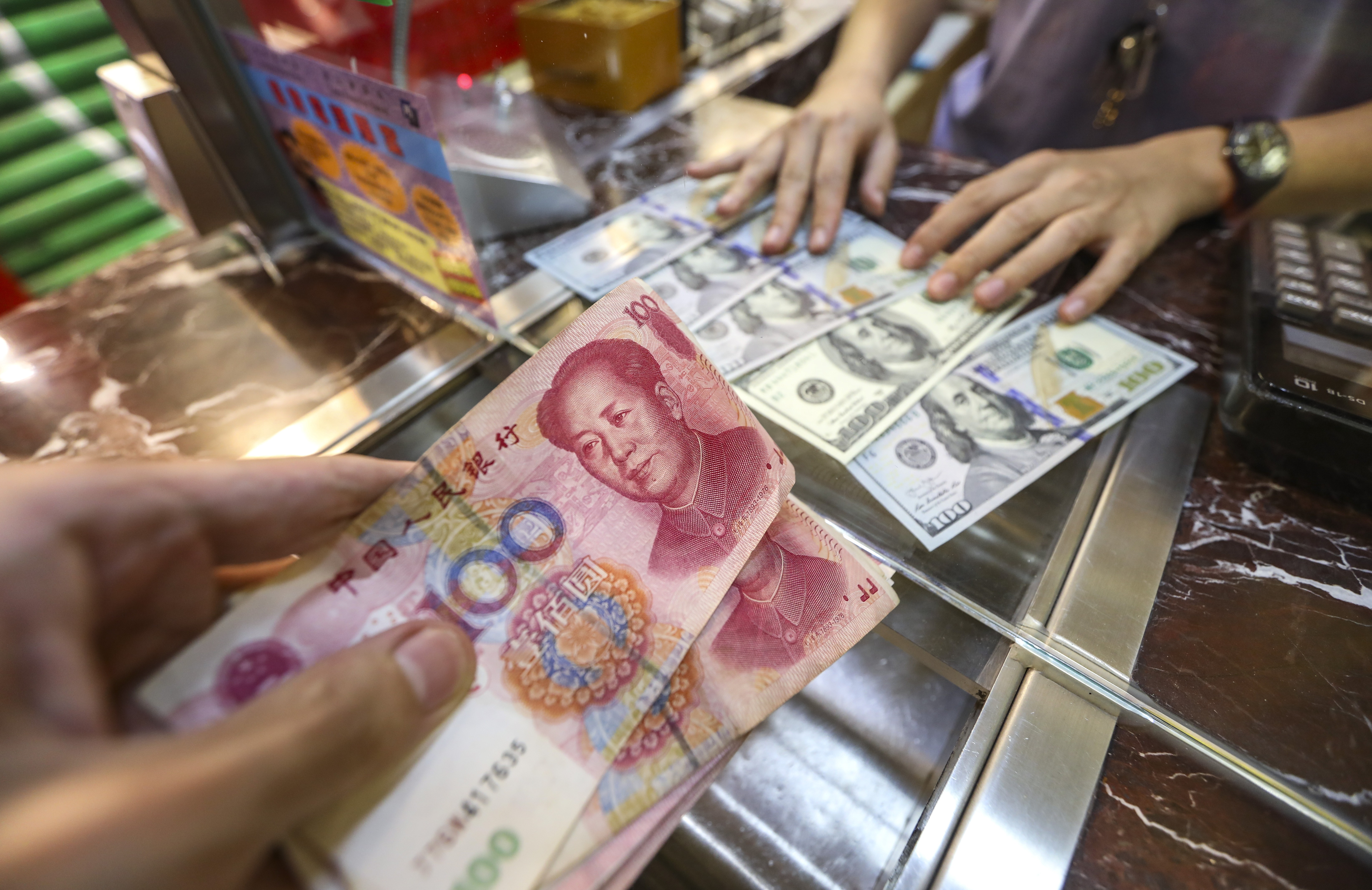 Is it a fair exchange or a case of the pot calling the kettle black? Chinese yuan and US dollars at a money exchange shop in Causeway Bay, Hong Kong, on August 5. Photo: Roy Issa