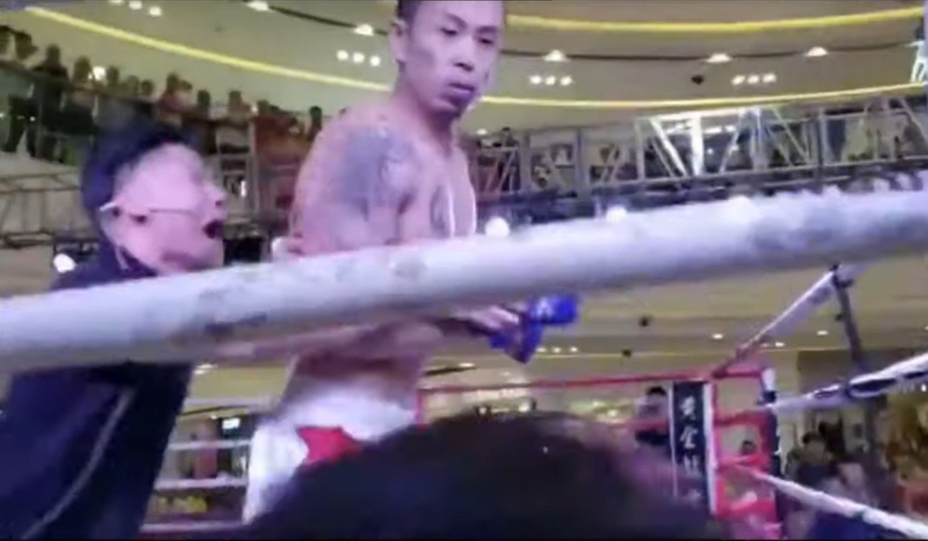 The referee pushes Xuan Wu away after he knocks out Tan Long.