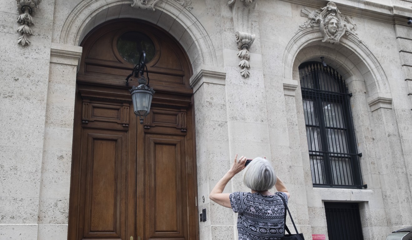 A pedestrian stops to take a photo of Jeffrey Epstein's town house on the Upper East Side of Manhattan on August 13. Photo: AP