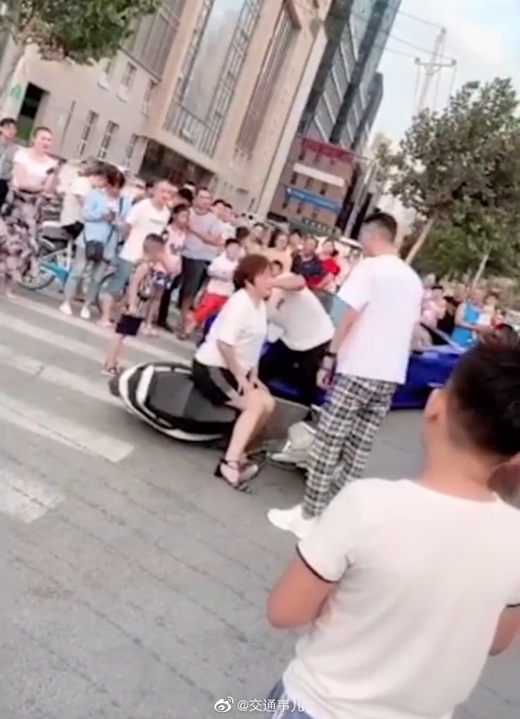 A blogger, his mother, and a friend with a camera pull the road accident stunt in Zhengzhou, Henan province, that was to end in detention and a fine for them all. Photo: Weibo