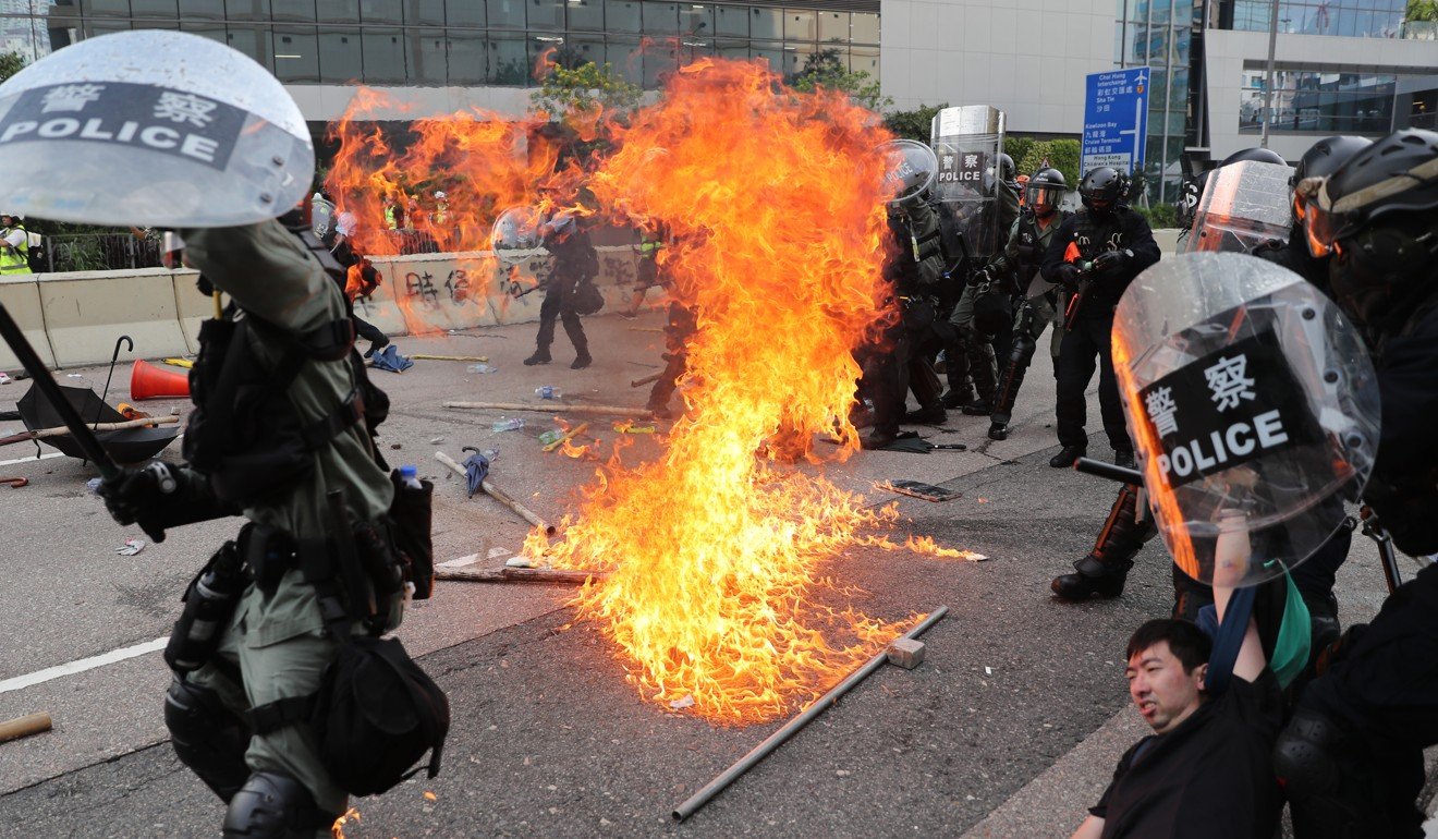 A petrol bomb lands near riot police during clashes close to the Ngau Tau Kok Police Station. Photo: Sam Tsang