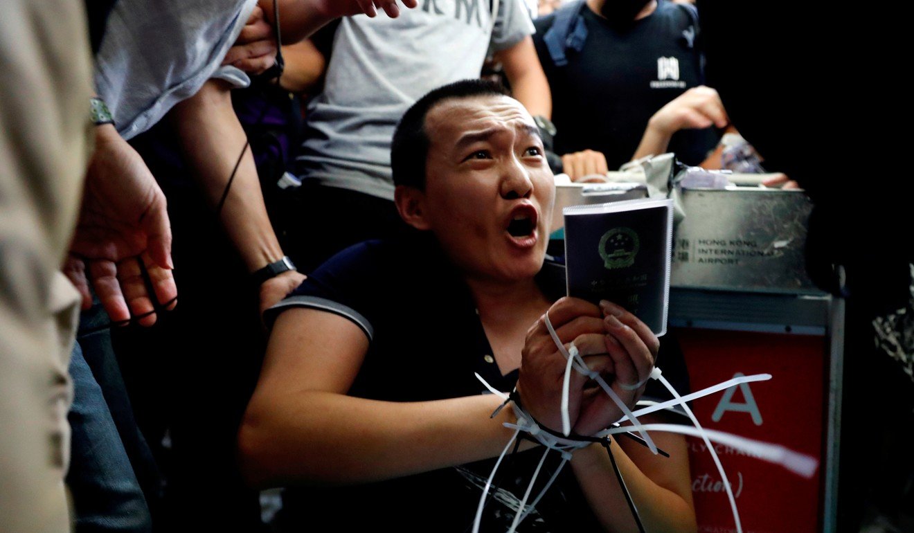 Fu Guohao, a reporter for the mainland’s Global Times website, is tied by protesters during a mass demonstration at Hong Kong International Airport on August 13. Photo: Reuters