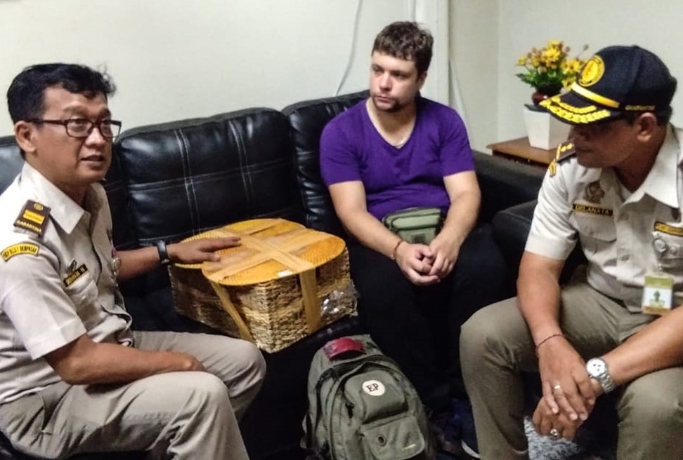 Detained Russian national Andrei Zhestkov (centre), who was jailed in July for attempting to smuggle a two-year-old orangutan out of Indonesia. Photo: AFP / Natural Resources Conservation Agency of Bali