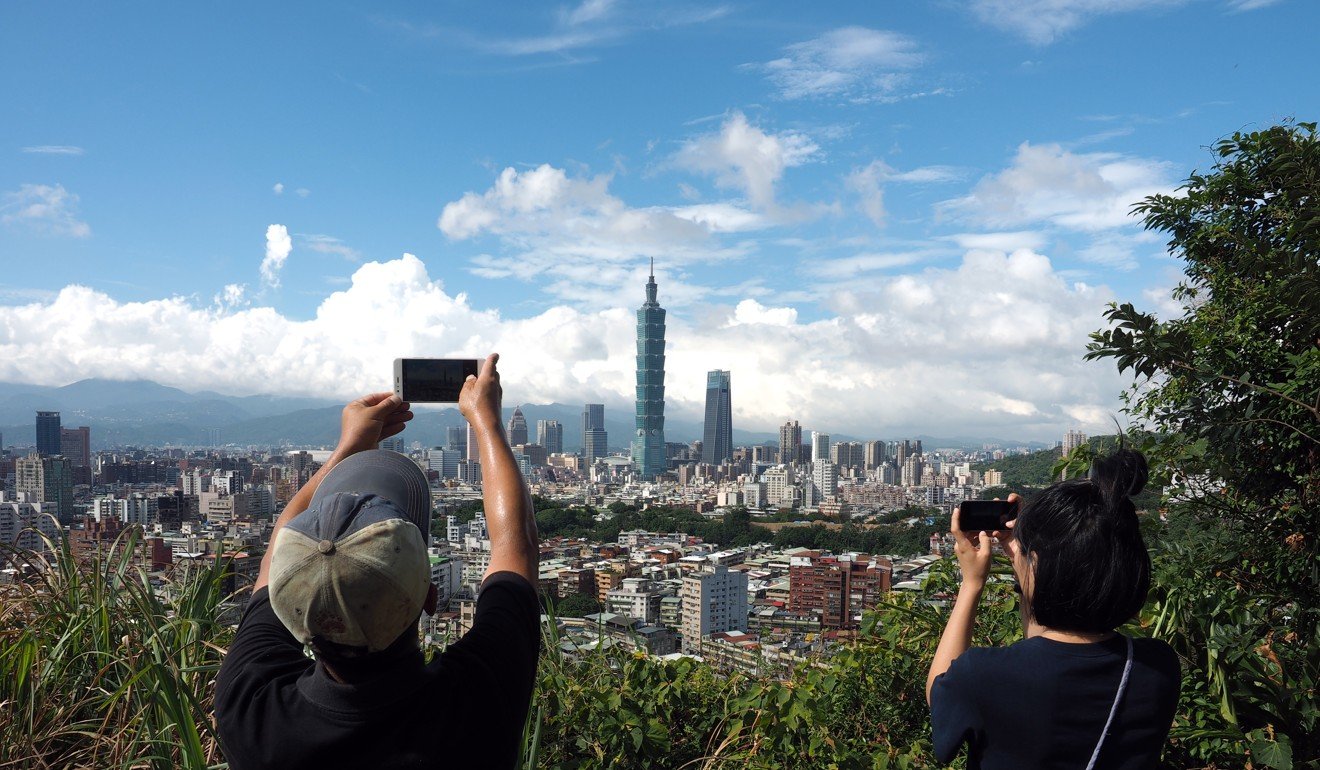 Tourists take photos of the Taipei 101 skyscraper in Taipei. Photo: EPA-EFE
