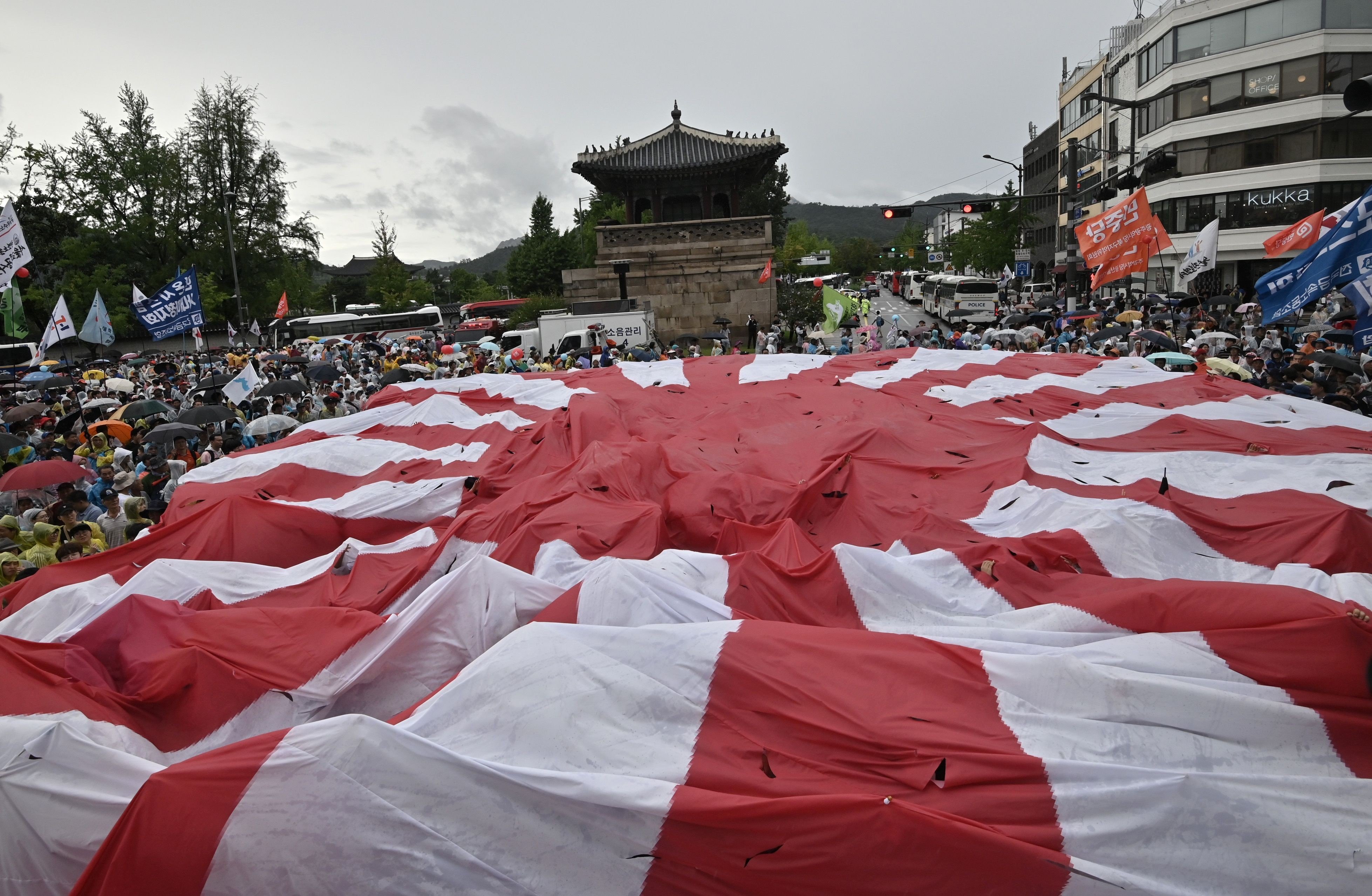 South Korean protesters tear a huge Japanese flag during a rally in Seoul on August 15 marking the anniversary of Korea’s liberation from Japan’s colonial rule. Photo: AFP