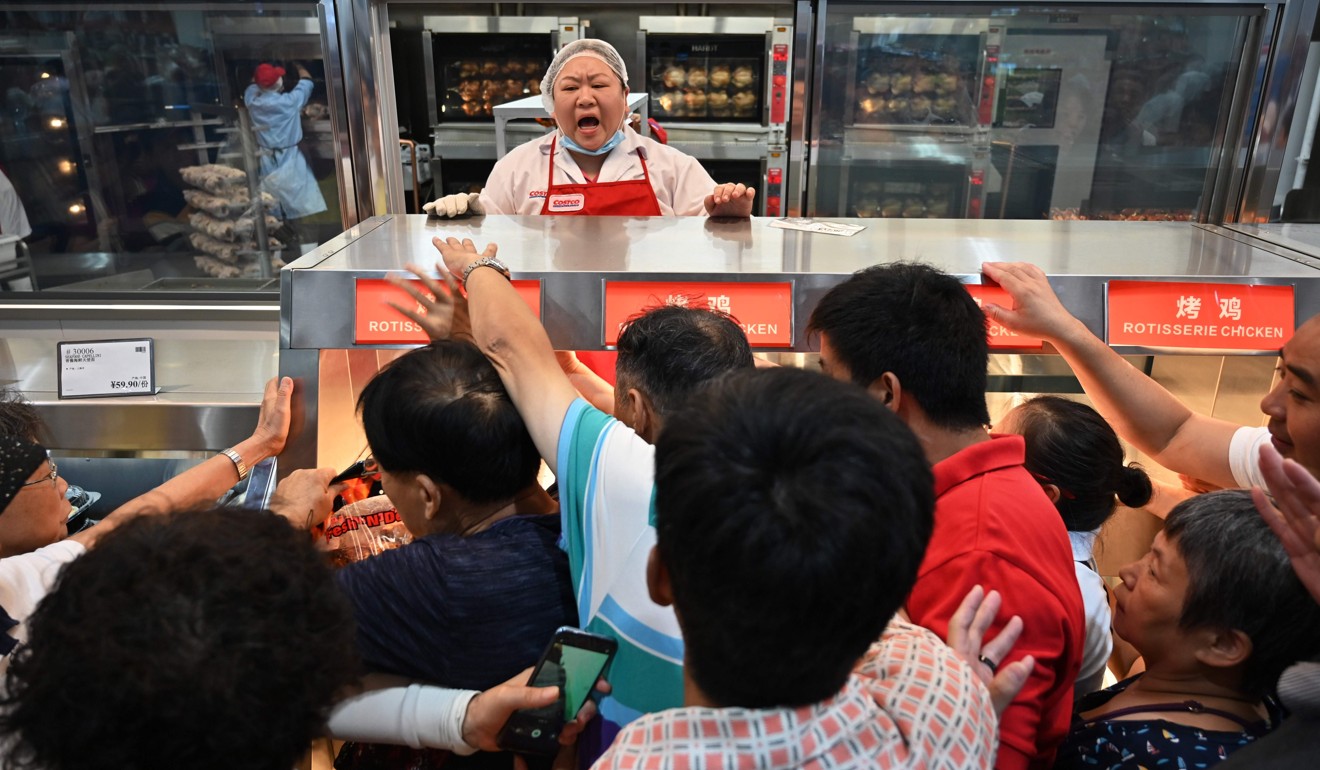 People try to get roast chicken at the Costco outlet in Shanghai on Tuesday. Photo: AFP