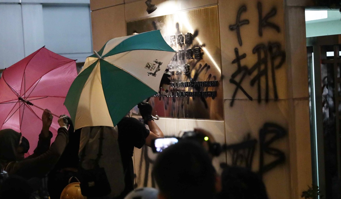 Protesters spray derogatory graffiti over the sign of the central government’s liaison office in Sai Ying Pun on July 21. Photo: Edmond So