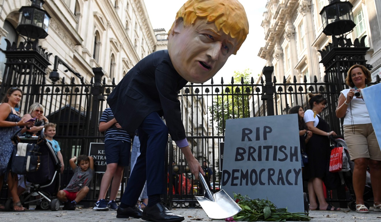 A masked demonstrator protests outside Downing Street. Photo: AFP
