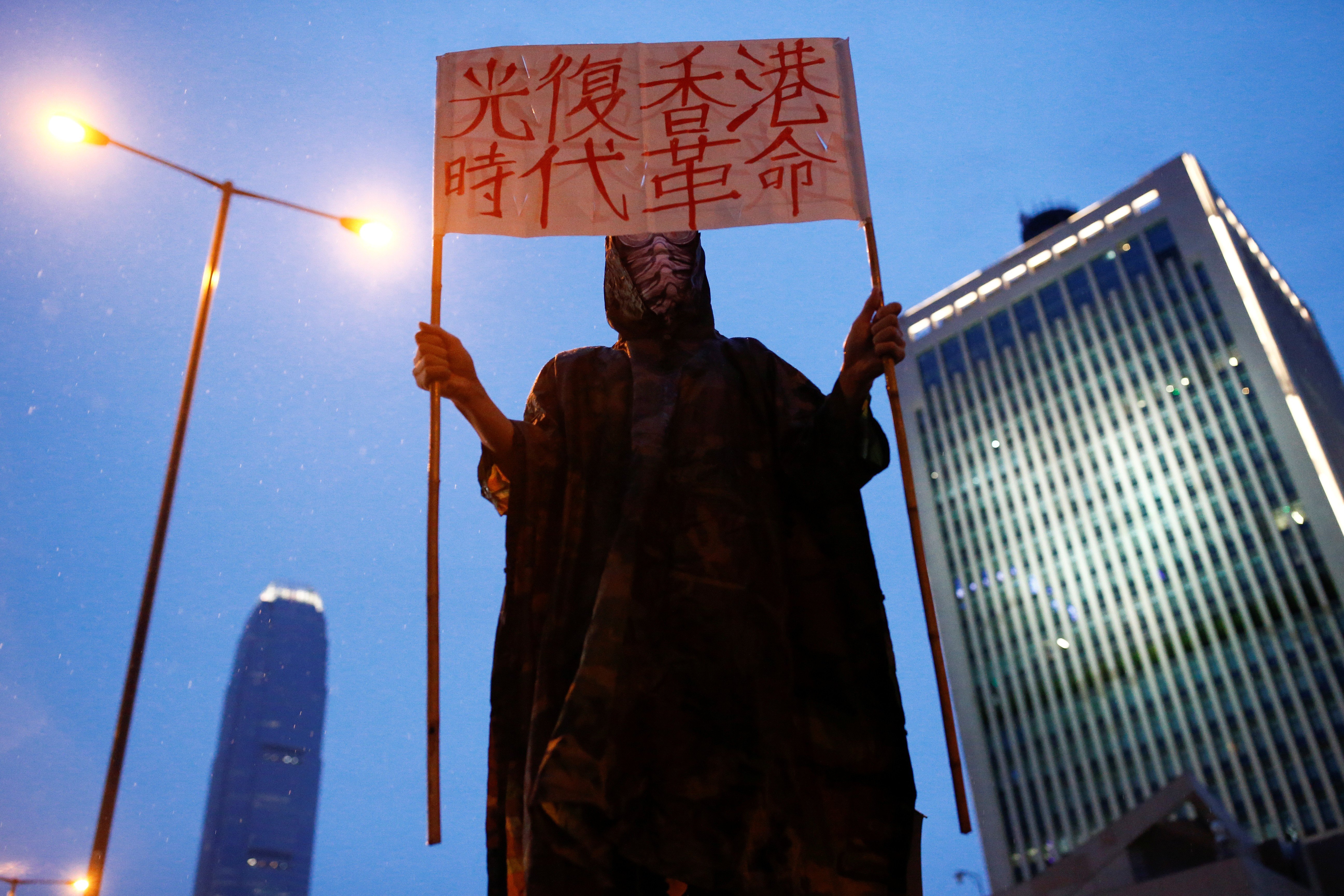 A protester holds a placard that reads “Liberate Hong Kong, revolution of our times” outside the People’s Liberation Army headquarters in Hong Kong. Photo: Reuters