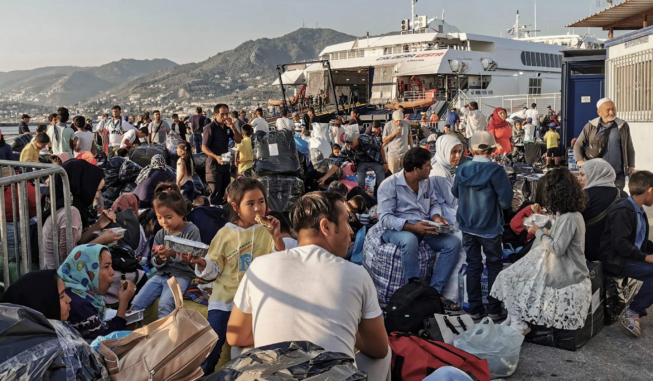 Refugees and migrants wait to board a ship at the port of Mytilene on Lesbos. Photo: AFP